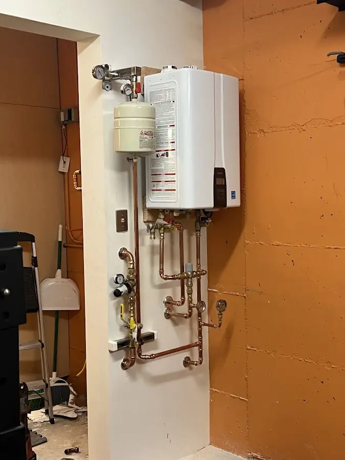Plumbing technician inspecting water heater connections in Middlefield